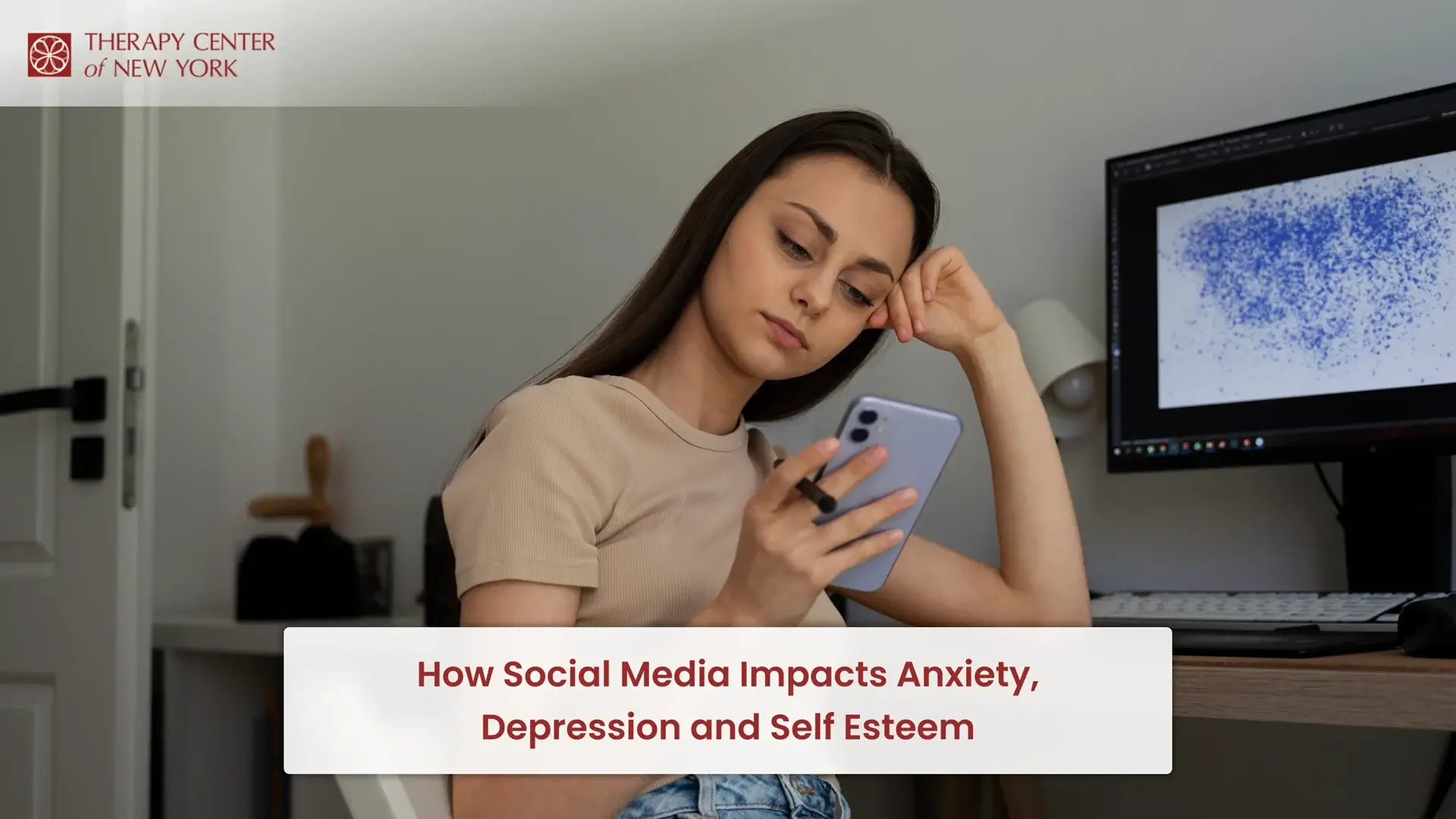 Woman looking at her phone while sitting at a desk, illustrating how social media impacts anxiety, depression and self esteem
