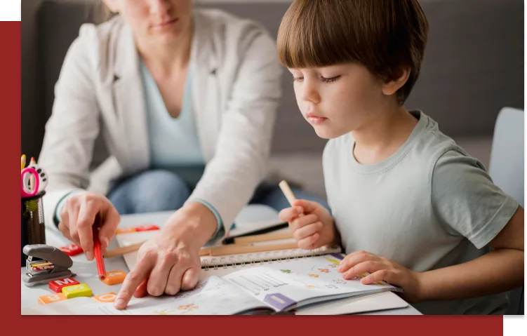 Mother helping child with homework, pointing at a workbook with colorful stickers and educational materials.